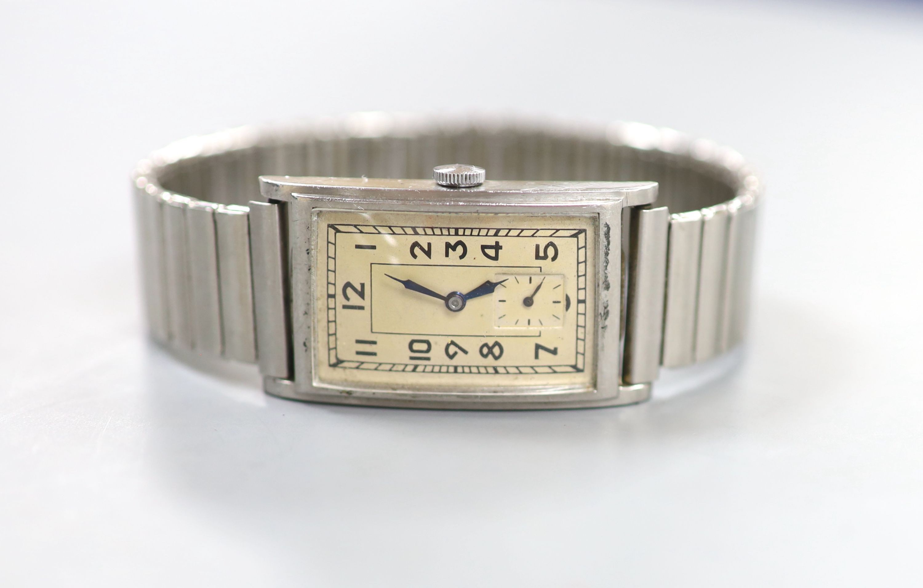 A gentleman's 1930's? stainless steel Omega manual wind rectangular dial wrist watch, on associated flexible bracelet, case diameter 23mm.